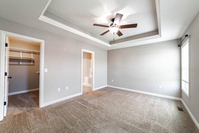 5506 Murfreesboro Dr, Columbia, MO 65201 - unfurnished bedroom featuring a raised ceiling, carpet floors, a spacious closet, and multiple windows
