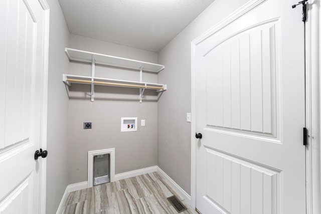 5506 Murfreesboro Dr, Columbia, MO 65201 - washroom with hookup for an electric dryer, hookup for a washing machine, light wood finished floors, baseboards, and a textured ceiling