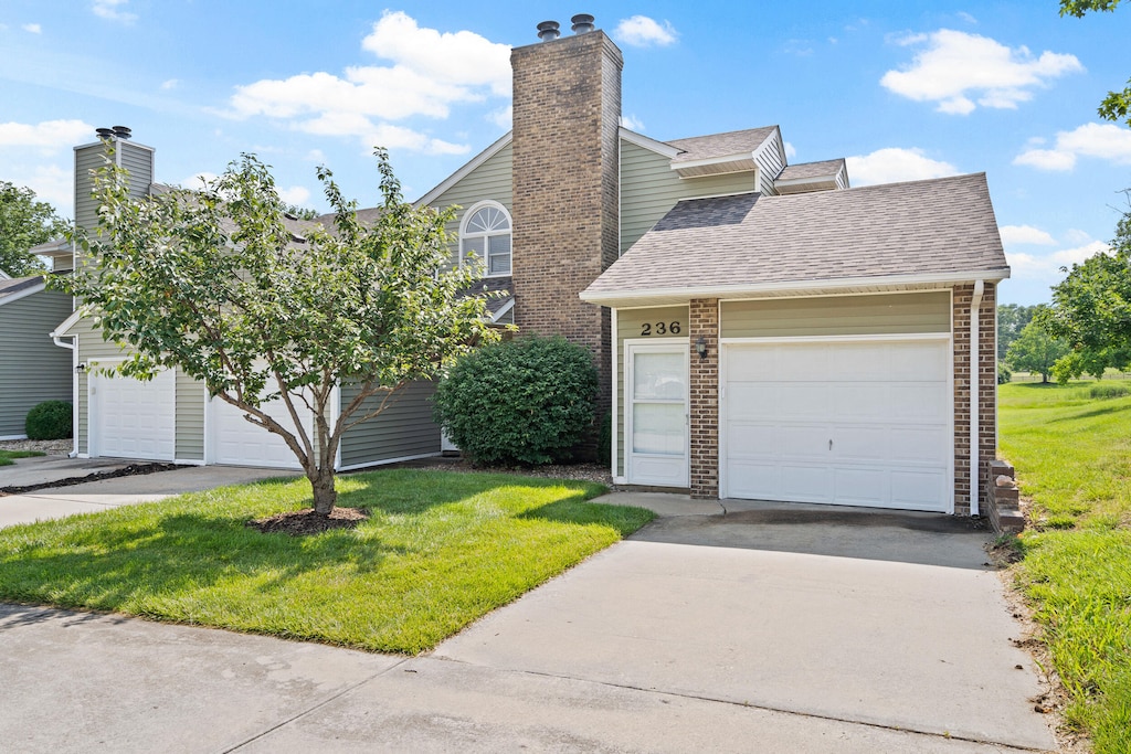 236 W Green Meadows Rd, Columbia, MO 65203 - view of front of property featuring a front lawn, a shingled roof, a chimney, and brick siding