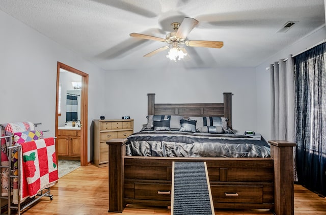 1402 Jean Rae Dr, Columbia, MO 65203 - bedroom featuring light wood-style floors, connected bathroom, ceiling fan, and a textured ceiling