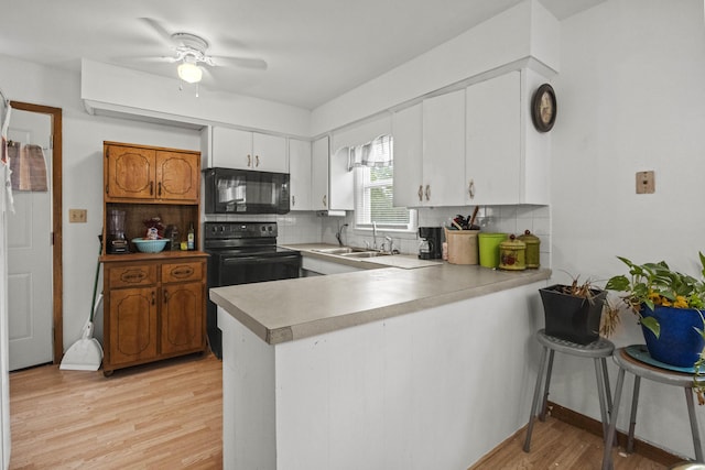 1302 Bradley Ln, Fulton, MO 65251 - kitchen with black appliances, a sink, a peninsula, and tasteful backsplash