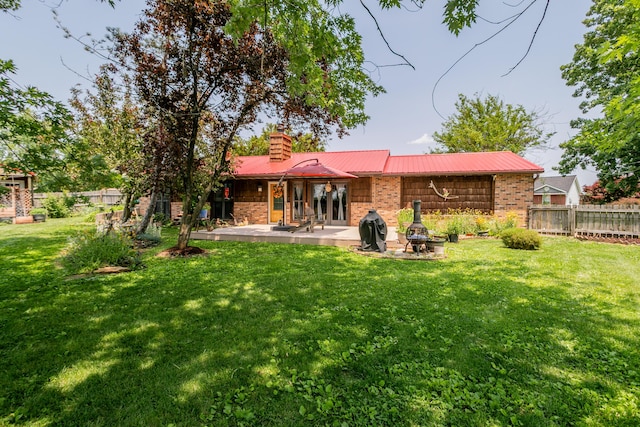 7901 N Chesley Dr, Columbia, MO 65202 - back of property featuring brick siding, metal roof, a patio area, and a chimney