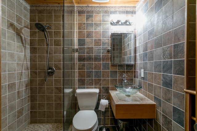 7901 N Chesley Dr, Columbia, MO 65202 - bathroom featuring a tile shower, toilet, vanity, and tile walls