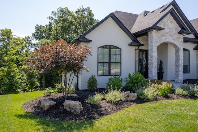 7501 Kirby Knowle Ct, Columbia, MO 65203 - view of home's exterior featuring stone siding, stucco siding, a lawn, and a shingled roof