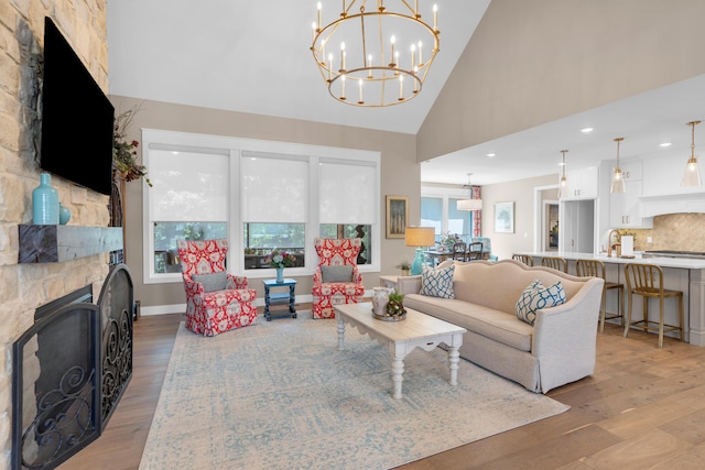 7501 Kirby Knowle Ct, Columbia, MO 65203 - living room with light wood-type flooring, high vaulted ceiling, a chandelier, a stone fireplace, and recessed lighting