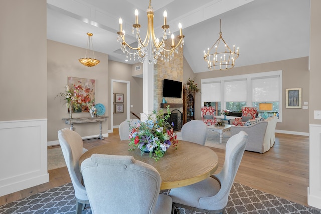 7501 Kirby Knowle Ct, Columbia, MO 65203 - dining area with a chandelier, wood finished floors, high vaulted ceiling, and a fireplace