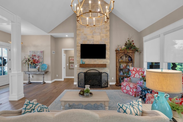 7501 Kirby Knowle Ct, Columbia, MO 65203 - living area featuring wood finished floors, high vaulted ceiling, a chandelier, a stone fireplace, and ornate columns