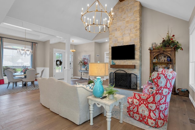 7501 Kirby Knowle Ct, Columbia, MO 65203 - living room with a chandelier, high vaulted ceiling, wood finished floors, and a stone fireplace