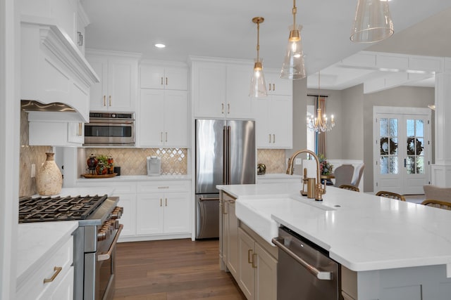 7501 Kirby Knowle Ct, Columbia, MO 65203 - kitchen with premium appliances, dark wood finished floors, a kitchen island with sink, a chandelier, and white cabinets