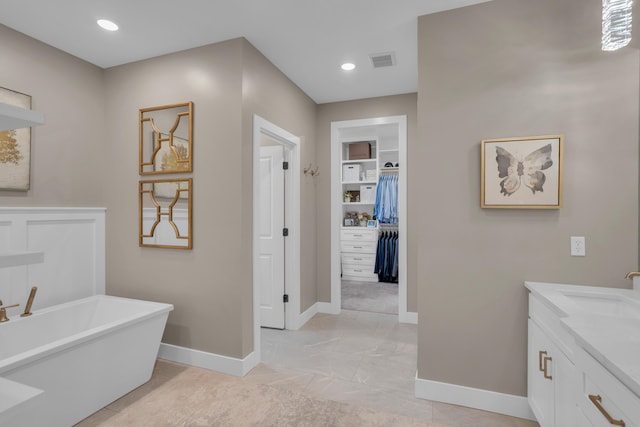 7501 Kirby Knowle Ct, Columbia, MO 65203 - bathroom with a freestanding bath, vanity, a walk in closet, and recessed lighting