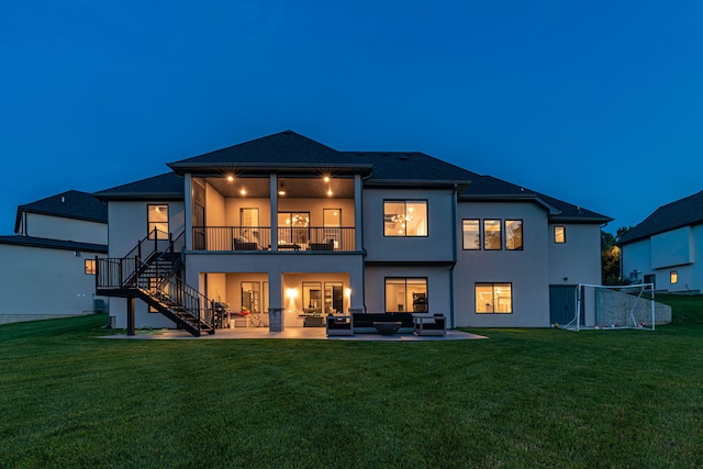 7305 Sella Ct, Columbia, MO 65203 - back of house at twilight with an outdoor hangout area, stairs, stucco siding, a balcony, and a patio area