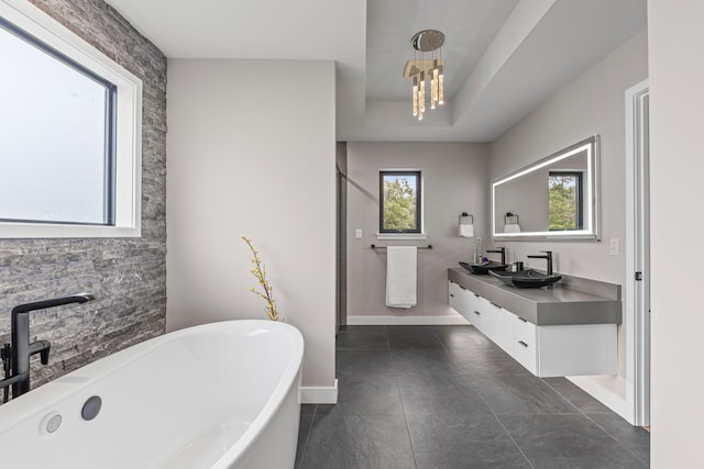 7305 Sella Ct, Columbia, MO 65203 - bathroom with a soaking tub, double vanity, baseboards, a chandelier, and tile patterned flooring
