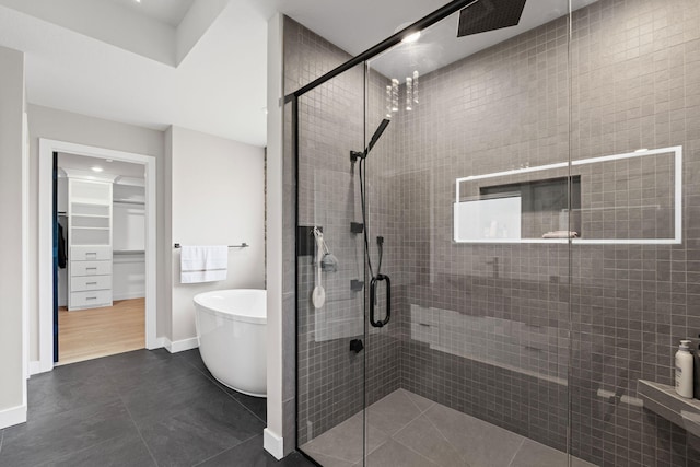 7305 Sella Ct, Columbia, MO 65203 - full bathroom with a stall shower, a freestanding tub, a walk in closet, and baseboards