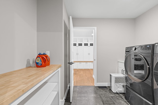 7305 Sella Ct, Columbia, MO 65203 - washroom with cabinet space, baseboards, independent washer and dryer, and dark tile patterned flooring