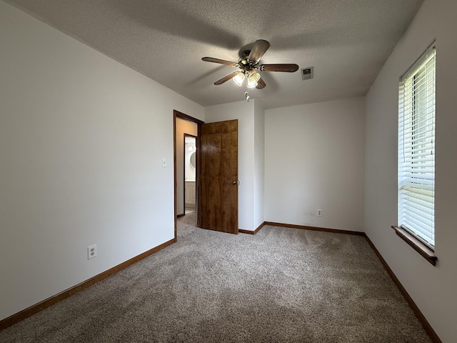 2009 N Waterfront Dr Unit G, Columbia, MO 65202 - carpeted spare room with plenty of natural light, ceiling fan, a textured ceiling, and baseboards
