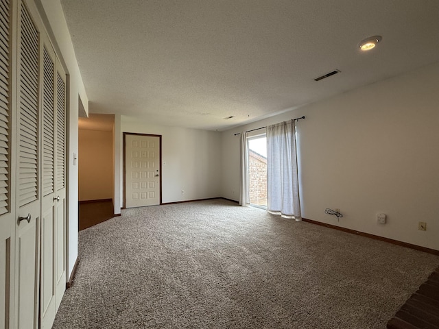 2009 N Waterfront Dr Unit G, Columbia, MO 65202 - unfurnished bedroom featuring baseboards, carpet flooring, a textured ceiling, and multiple closets