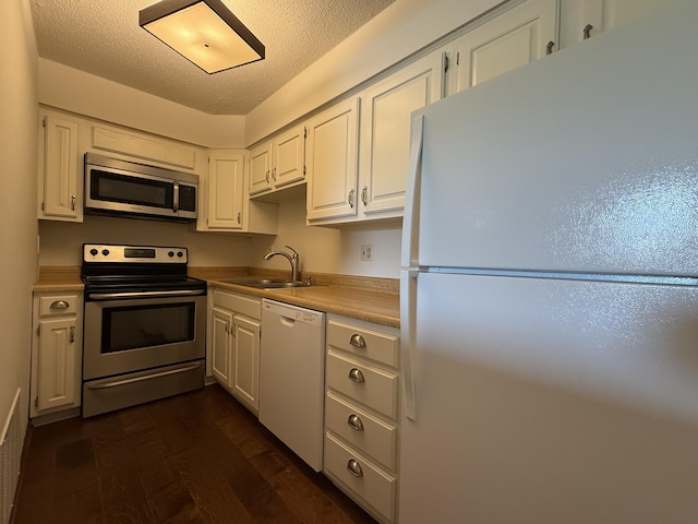 2009 N Waterfront Dr Unit G, Columbia, MO 65202 - kitchen with stainless steel appliances, a sink, white cabinets, dark wood-style floors, and light countertops
