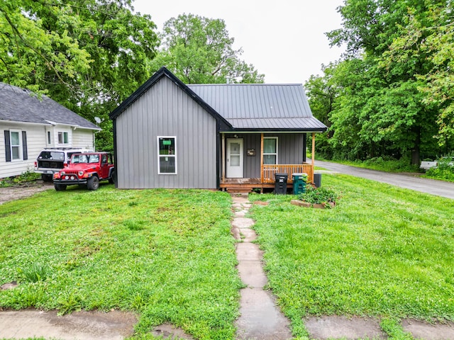 210 Oaklawn Ave, Fayette, MO 65248 - view of front of home featuring board and batten siding, covered porch, a front lawn, and metal roof