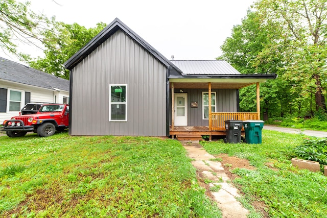 210 Oaklawn Ave, Fayette, MO 65248 - view of front facade featuring a porch, a front lawn, metal roof, and board and batten siding