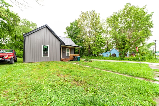 210 Oaklawn Ave, Fayette, MO 65248 - view of front of property with covered porch, a front lawn, metal roof, and board and batten siding