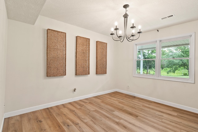 5700 Wilhite Rd, Columbia, MO 65202 - spare room featuring light wood-style floors, a chandelier, baseboards, and a textured ceiling