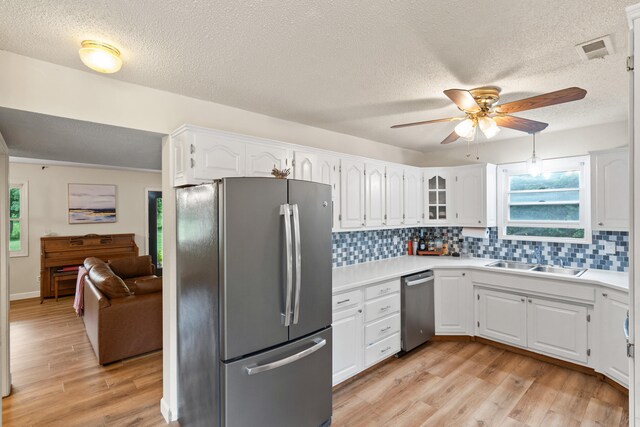 5700 Wilhite Rd, Columbia, MO 65202 - kitchen with stainless steel appliances, a sink, a ceiling fan, white cabinets, and decorative backsplash