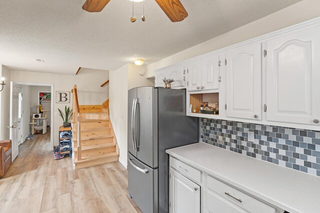 5700 Wilhite Rd, Columbia, MO 65202 - kitchen featuring freestanding refrigerator, white cabinetry, a ceiling fan, tasteful backsplash, and light wood-style flooring