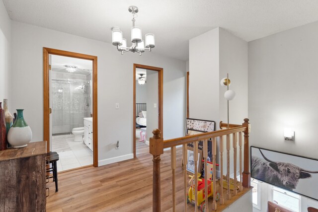 5700 Wilhite Rd, Columbia, MO 65202 - corridor with an upstairs landing, a chandelier, light wood finished floors, and baseboards