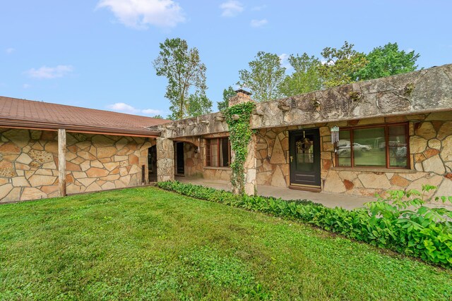 304 W Maple St, Auxvasse, MO 65231 - rear view of property featuring stone siding, a yard, and a chimney