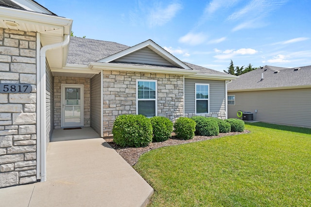 5817 Geyser Blvd, Columbia, MO 65202 - entrance to property featuring stone siding, a yard, cooling unit, and a shingled roof
