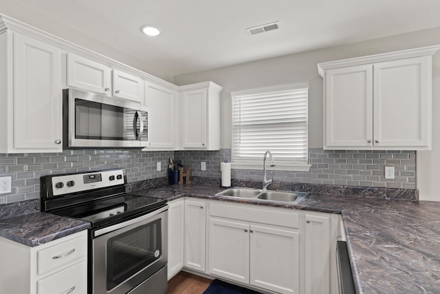 5817 Geyser Blvd, Columbia, MO 65202 - kitchen with appliances with stainless steel finishes, a sink, white cabinets, tasteful backsplash, and recessed lighting