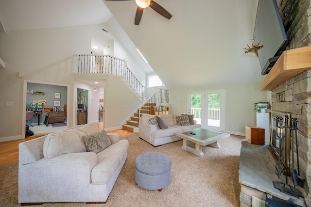 10060 E David Allen Rd, Columbia, MO 65201 - living area with high vaulted ceiling, a stone fireplace, stairway, ceiling fan, and baseboards