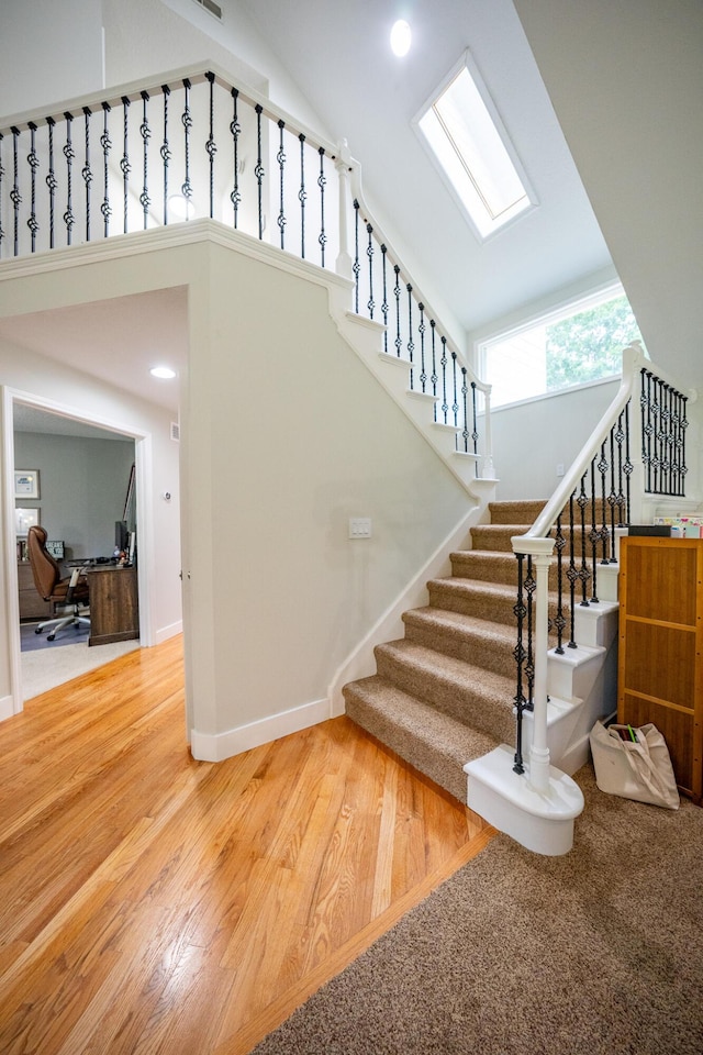 10060 E David Allen Rd, Columbia, MO 65201 - staircase with wood finished floors, high vaulted ceiling, baseboards, and recessed lighting
