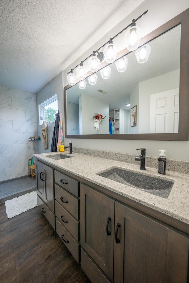 10060 E David Allen Rd, Columbia, MO 65201 - full bath with wood finished floors, double vanity, a textured ceiling, and tiled shower