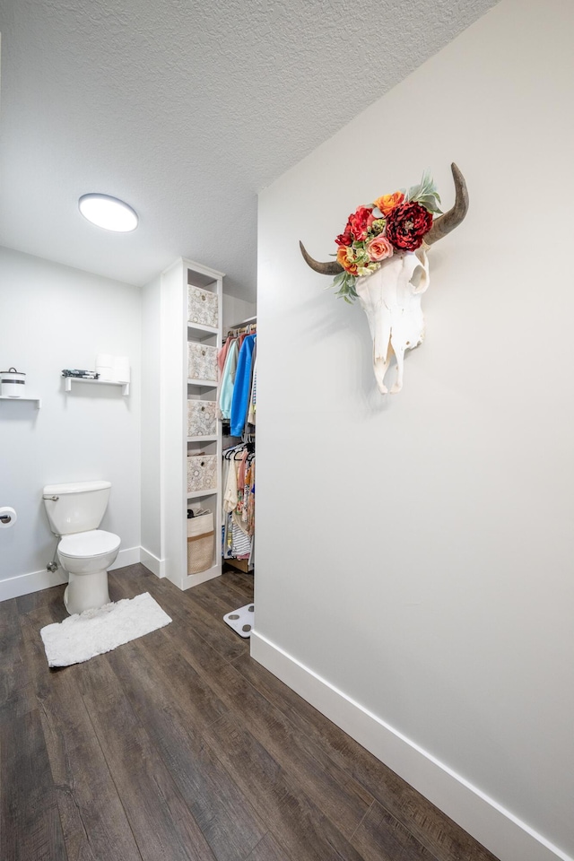 10060 E David Allen Rd, Columbia, MO 65201 - bathroom with wood finished floors, toilet, baseboards, and a textured ceiling