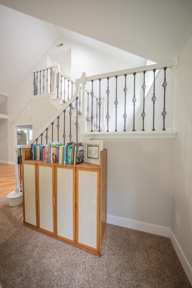 10060 E David Allen Rd, Columbia, MO 65201 - staircase featuring carpet floors, vaulted ceiling, and baseboards