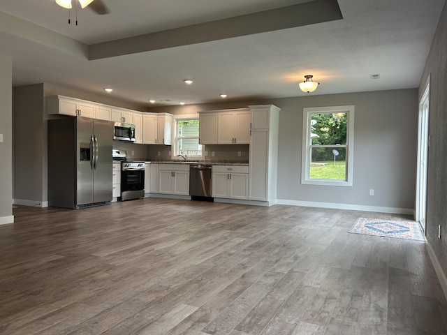 915 Colorado St, Jefferson City, MO 65109 - kitchen featuring appliances with stainless steel finishes, wood finished floors, plenty of natural light, white cabinets, and recessed lighting