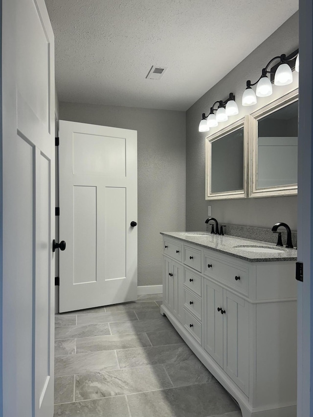 915 Colorado St, Jefferson City, MO 65109 - full bathroom with double vanity, a textured ceiling, and baseboards