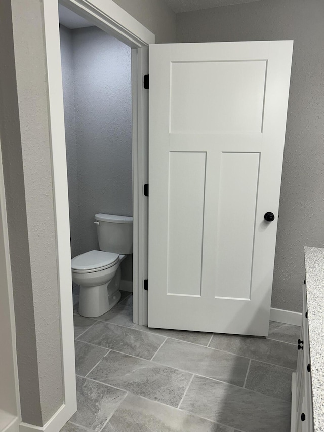 915 Colorado St, Jefferson City, MO 65109 - bathroom with vanity, toilet, a textured wall, and baseboards
