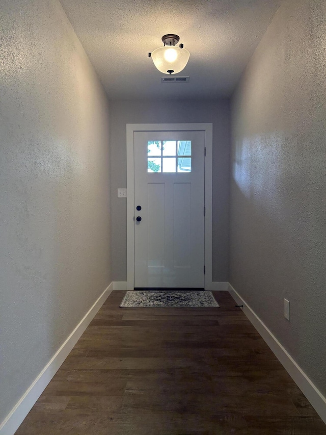 915 Colorado St, Jefferson City, MO 65109 - entryway with a textured wall, dark wood-style flooring, baseboards, and a textured ceiling