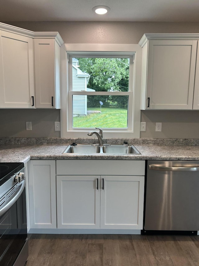915 Colorado St, Jefferson City, MO 65109 - kitchen featuring appliances with stainless steel finishes, a sink, white cabinets, dark wood-style flooring, and recessed lighting