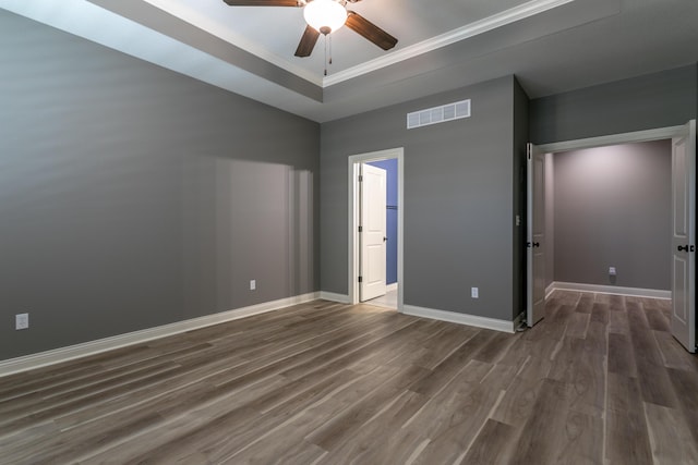 2016 Devonshire Dr, Columbia, MO 65203 - unfurnished bedroom with dark wood-type flooring, crown molding, a raised ceiling, and a ceiling fan