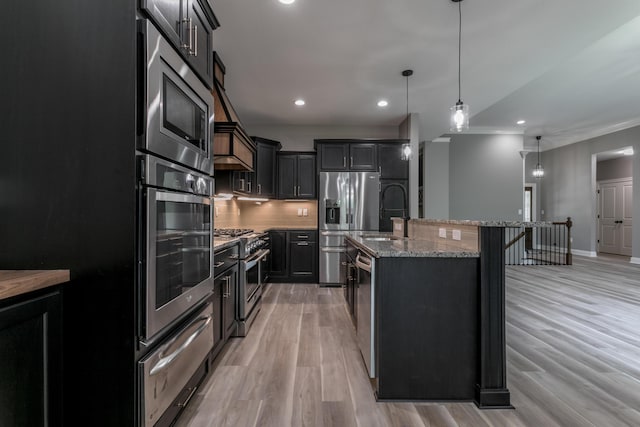2016 Devonshire Dr, Columbia, MO 65203 - kitchen with stainless steel appliances, a warming drawer, light stone countertops, an island with sink, and pendant lighting