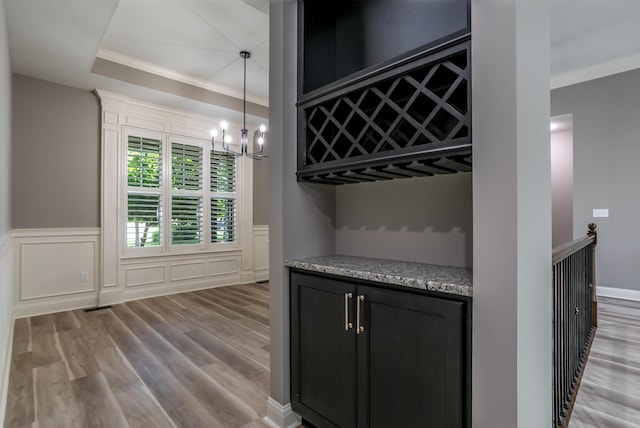 2016 Devonshire Dr, Columbia, MO 65203 - bar with a chandelier, wood finished floors, crown molding, a wainscoted wall, and decorative light fixtures