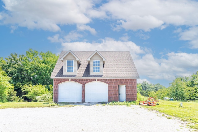 8801 S Ginn Ln, Columbia, MO 65201 - view of front of property featuring a detached garage, brick siding, roof with shingles, and a front yard