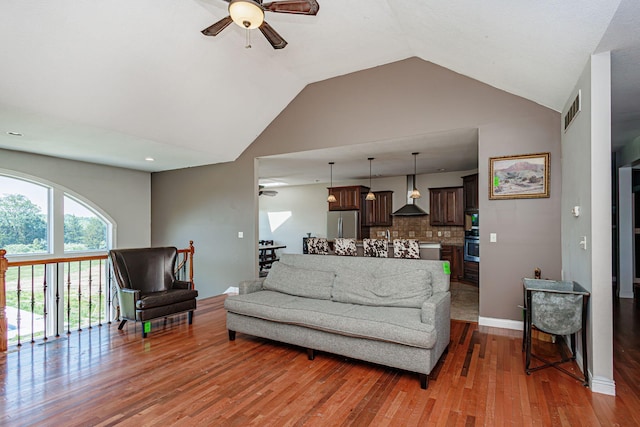 8801 S Ginn Ln, Columbia, MO 65201 - living area featuring a ceiling fan, wood finished floors, baseboards, and high vaulted ceiling
