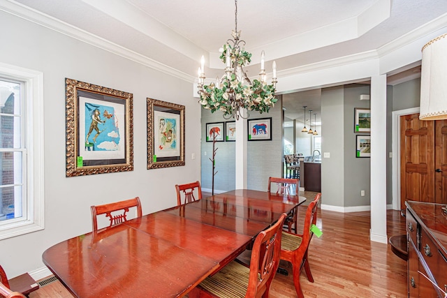 8801 S Ginn Ln, Columbia, MO 65201 - dining room with a chandelier, baseboards, light wood-style floors, a raised ceiling, and healthy amount of natural light