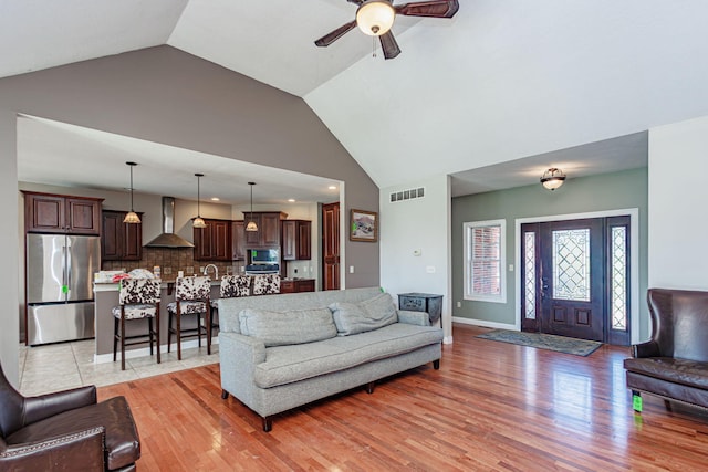 8801 S Ginn Ln, Columbia, MO 65201 - living area featuring ceiling fan, light wood finished floors, high vaulted ceiling, and baseboards