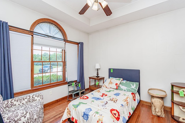 8801 S Ginn Ln, Columbia, MO 65201 - bedroom featuring wood finished floors, baseboards, a tray ceiling, and ceiling fan