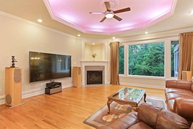 203 Foxwood Ct, Columbia, MO 65203 - living room featuring a raised ceiling, ceiling fan, light wood-style flooring, a fireplace with flush hearth, and crown molding